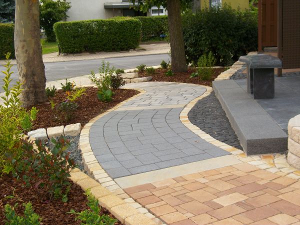 Gepflasterter Gartenweg mit Beeten