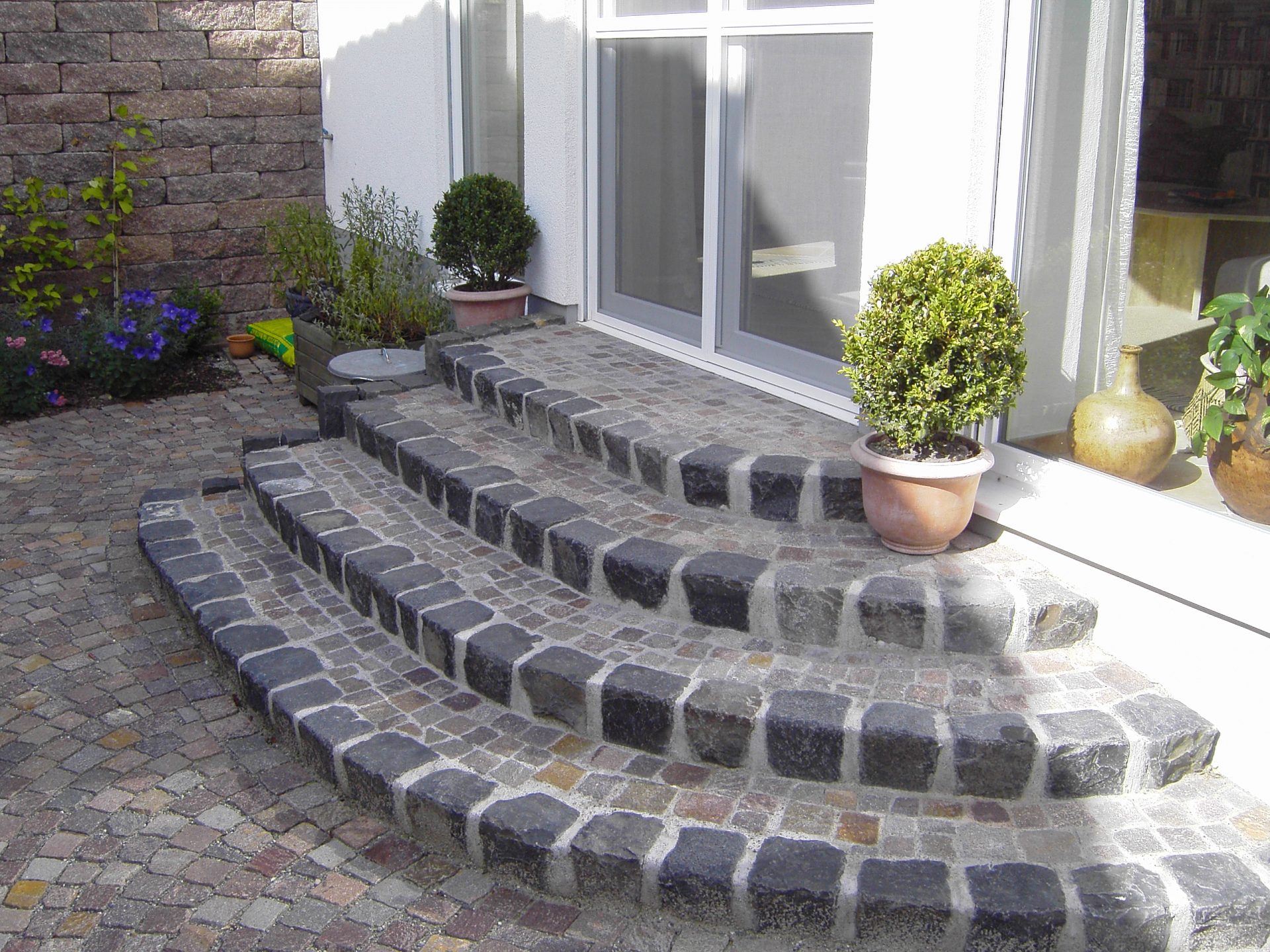 Natursteintreppe mit Topfpflanzen im Außenbereich