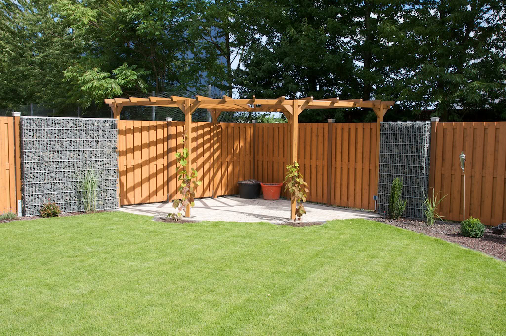 Garten mit Pergola und grünem Rasen.