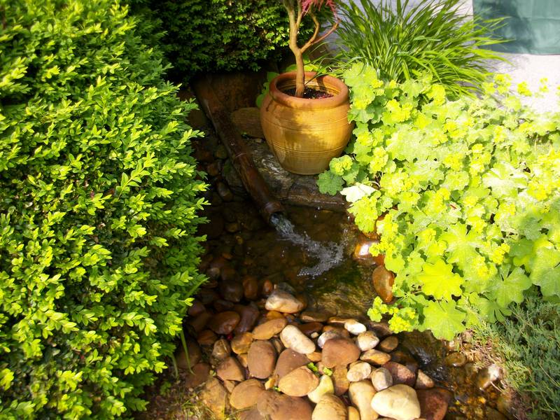 Garten mit Topfpflanze und kleinem Bachlauf