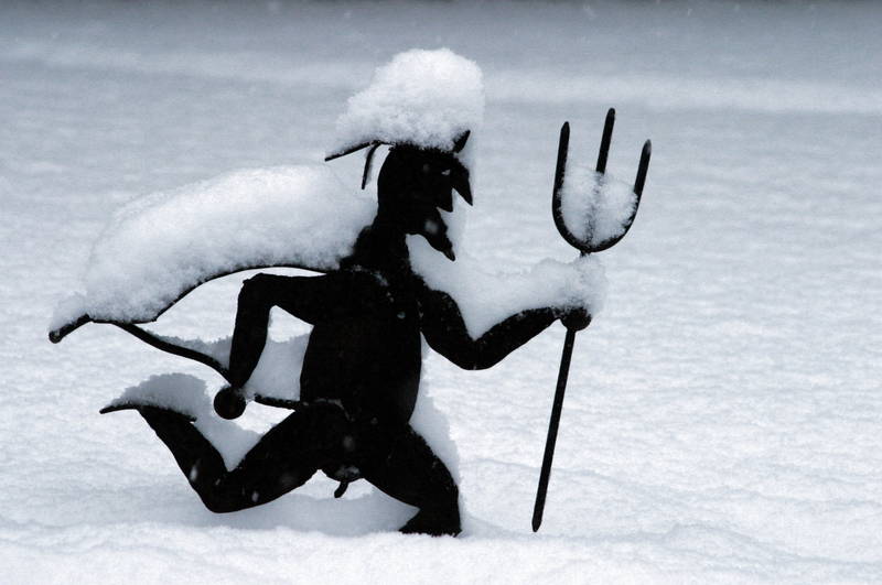 Schneebedeckte Figur mit Dreizack im Schnee