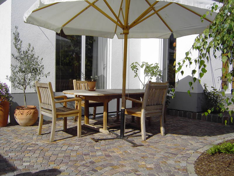 Terrasse mit Holzmöbeln und Sonnenschirm