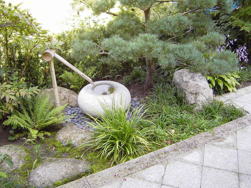 Japanischer Garten mit Wasserstein und Bambusrinne.