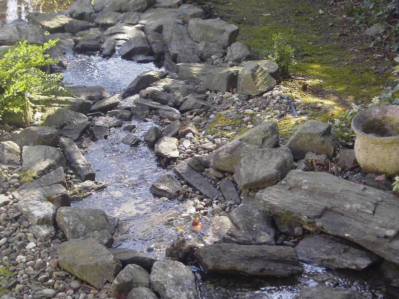 Kleiner Bach im Garten mit Steinen
