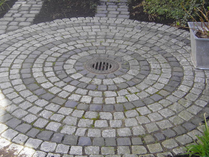 Runde Steinpflasterfläche mit Abflussgitter